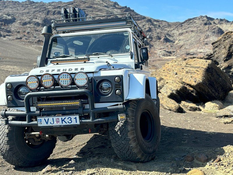 A Land Rover Defender super jeep standing on a highland track