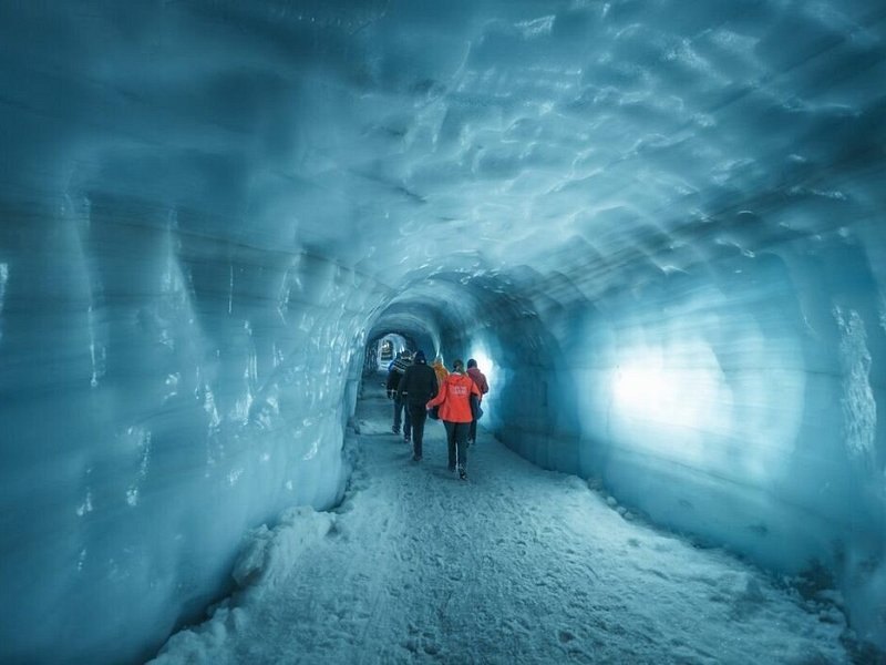 Two visitors small against the ice walls inside the Langjokull tunnel