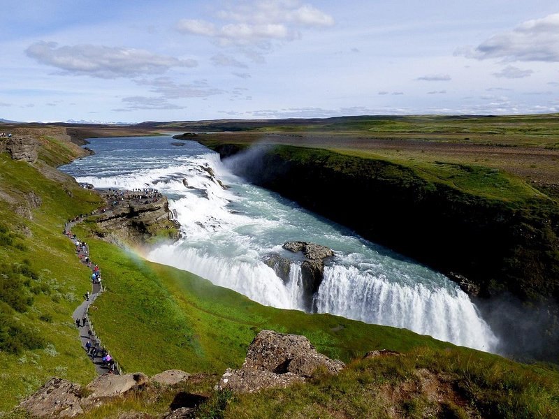 Gullfoss in summer with green banks running along the canyon