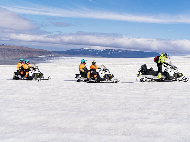 Three snowmobiles stopped on the snowfields of Langjokull